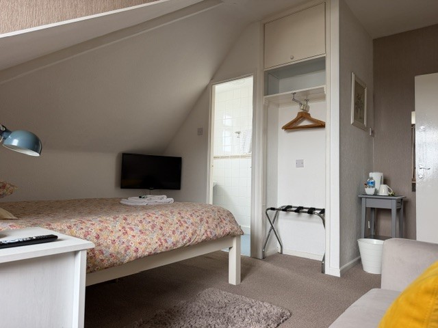 An En-suite double room with a television and the bathroom visible through the doorway