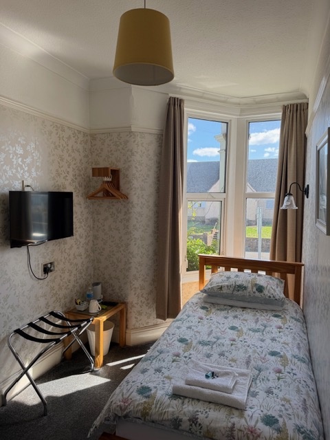 An En-suite single room with a bay window and hospitality tray