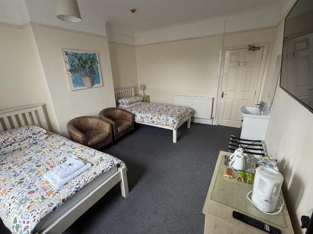 A Twin room with two single beds, chairs and a hospitality tray